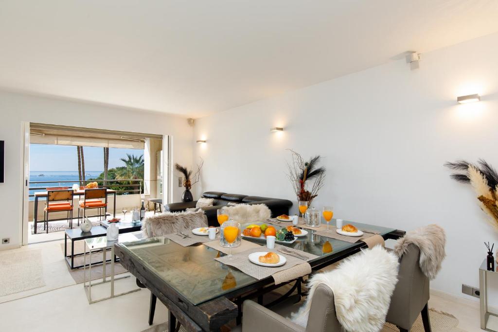 a living room with a table and a view of the ocean at 67 Croisette YourHostHelper in Cannes
