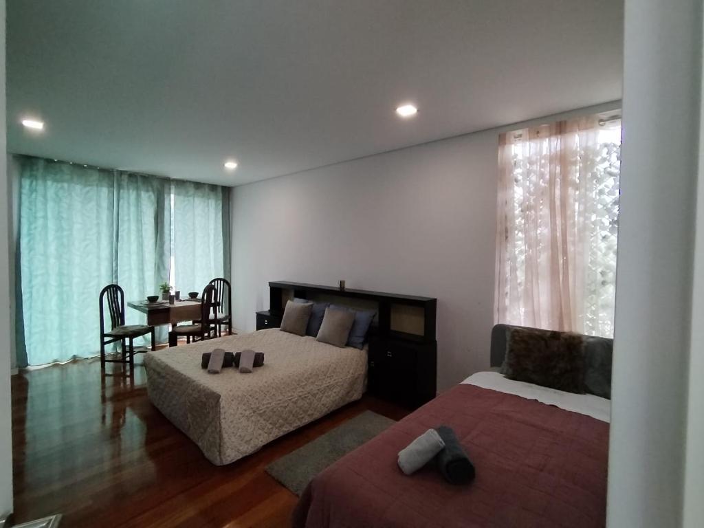 1 dormitorio con 2 camas y comedor con mesa en Quarto próximo a praia Vila Nova de Gaia en Valadares