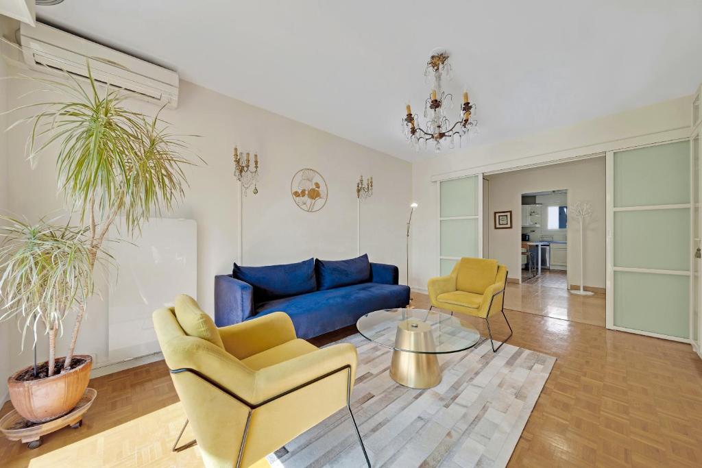 un salon avec un canapé bleu et deux chaises dans l'établissement T5 Spacieux, Parking, Proche Gare et Centre, à Dijon