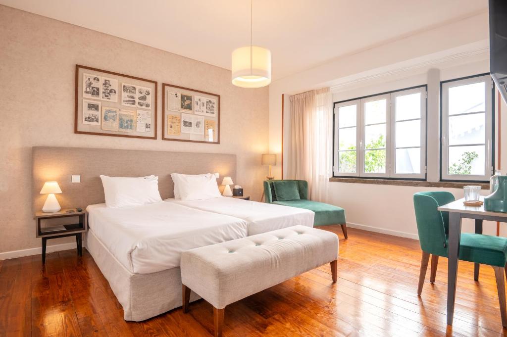 sypialnia z dużym łóżkiem, stołem i krzesłami w obiekcie Bica FLH Suites w Lizbonie