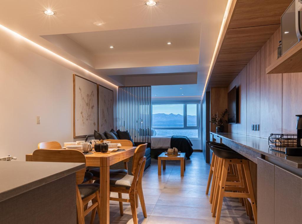 cocina y sala de estar con mesa y sillas en Lake Inn - Departamentos con costa de Lago en San Carlos de Bariloche