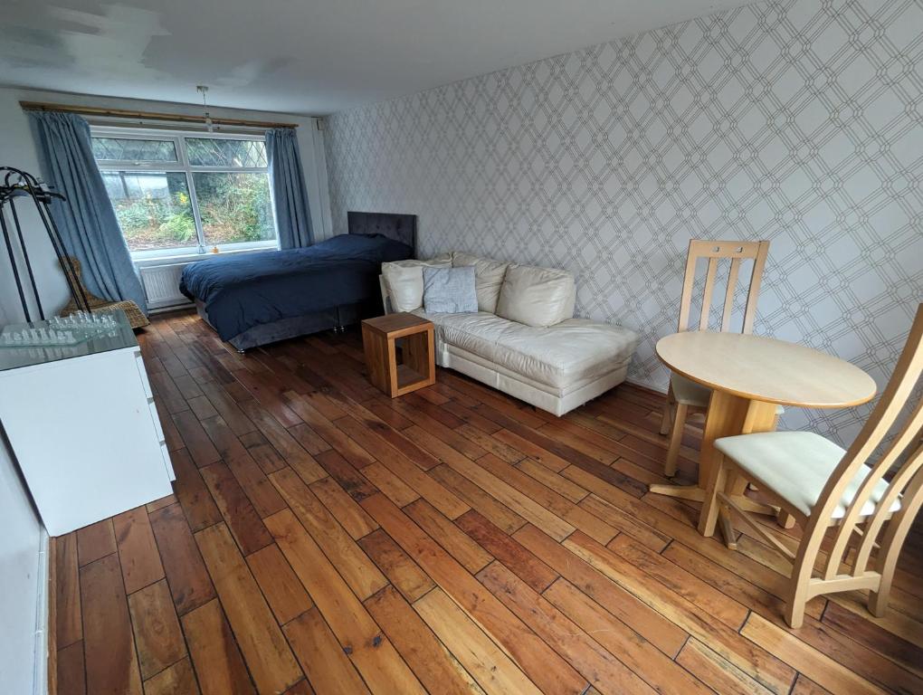 een woonkamer met een bank en een tafel bij Rooms close to City Centre in Beeston Hill