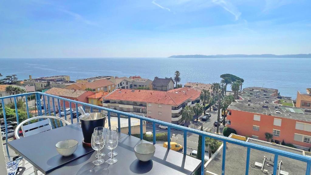 - un balcon avec une table et des verres à vin dans l'établissement Grand Hotel - Appartement, à Sainte-Maxime