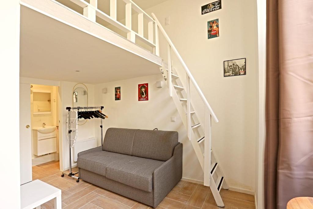 un salon avec un escalier et un canapé dans l'établissement Beautiful Apartment 11st District, à Paris