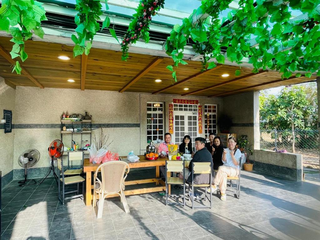 a group of people sitting at a table on a patio at 寧靜的家14人Villa獨立設施包棟戲水池烤肉區麻將廚房私人停車場 in Hengchun South Gate