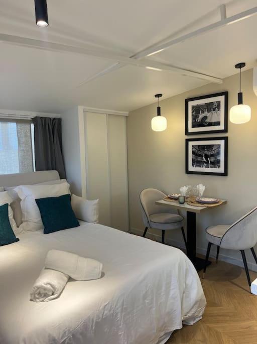 une chambre avec un lit et une table avec des chaises dans l'établissement Luxueux studio Cannes, à Cannes