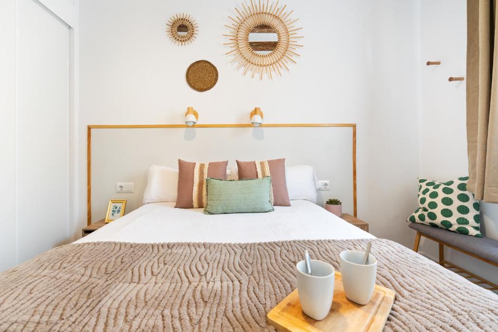 a bedroom with a bed with two white cups on a wooden tray at Lodging Apartments Almirall Beach 51 in Barcelona