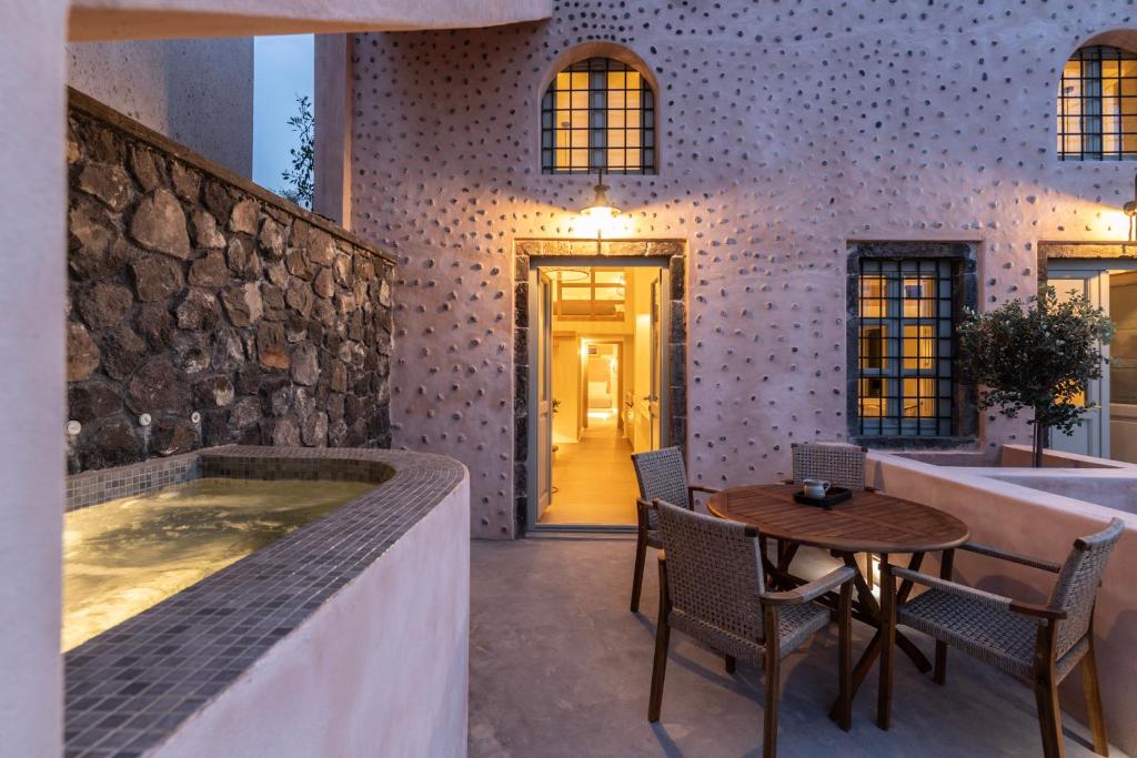 梅薩雷亞的住宿－Frescoes Luxury Suites，带浴缸和桌椅的浴室