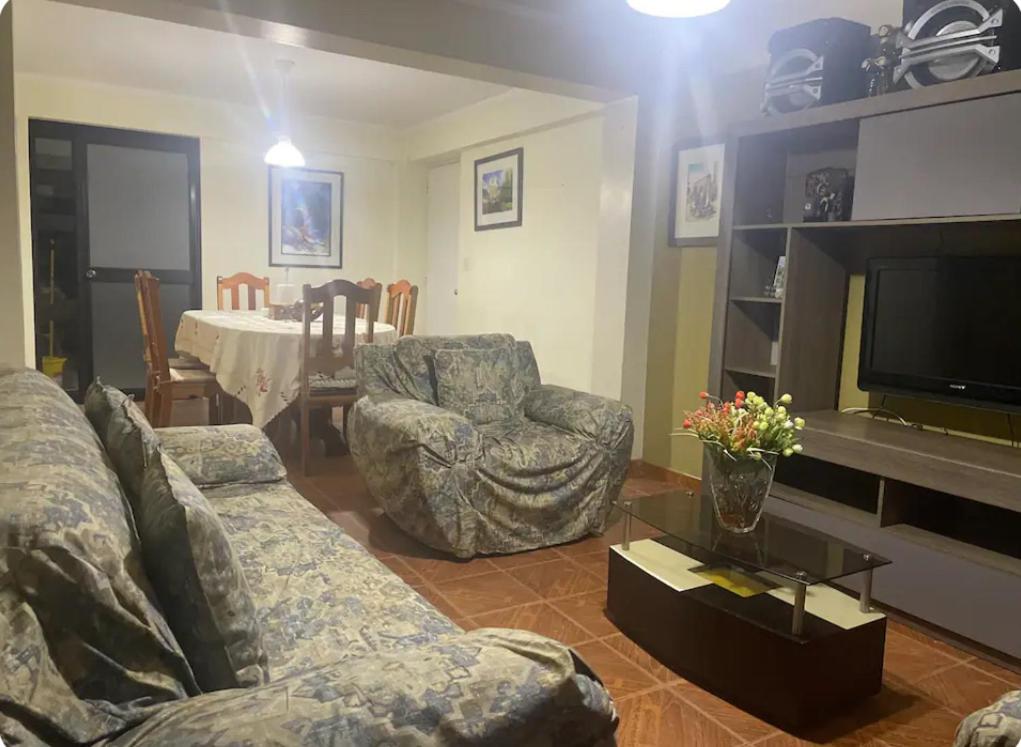 a living room with a couch and chairs and a television at Casa en la ciudad in Huaraz