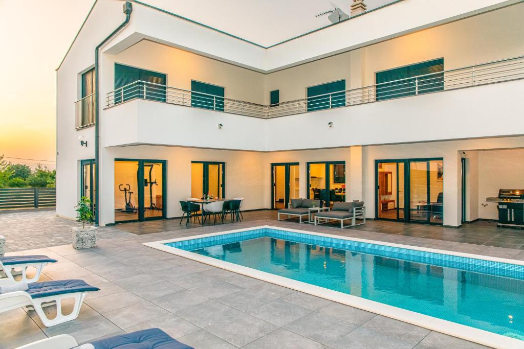 a villa with a swimming pool and a house at Villa Gräfin in Malinska
