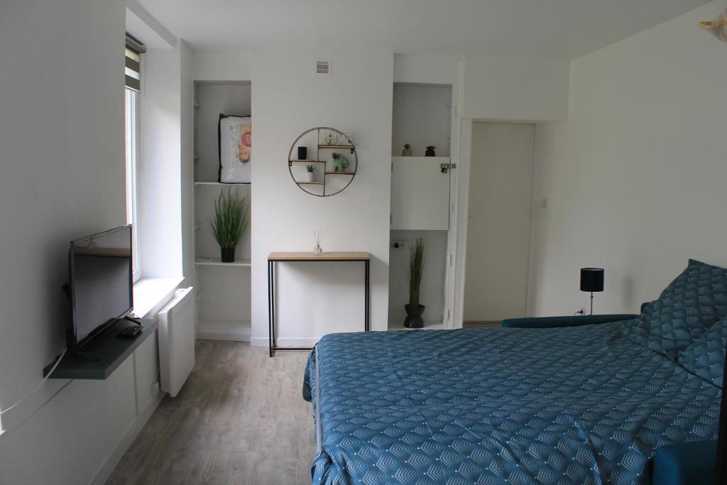 a bedroom with a blue bed and a television at Charmant Cachet in Sedan