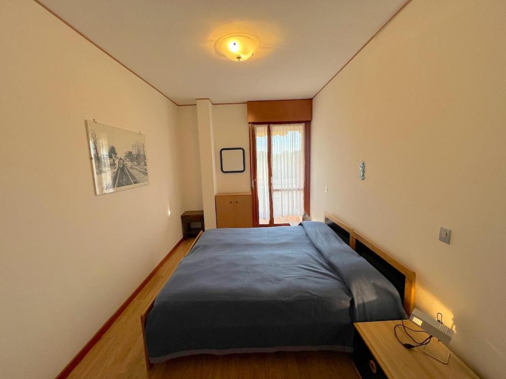 een slaapkamer met een bed in de hoek van een kamer bij Riviera Complex in Lignano Sabbiadoro