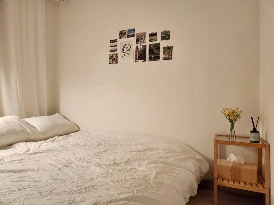 een slaapkamer met een bed en een tafel met foto's aan de muur bij Near Aju Uni Hospital, Everland, Starfield, etc in Suwon