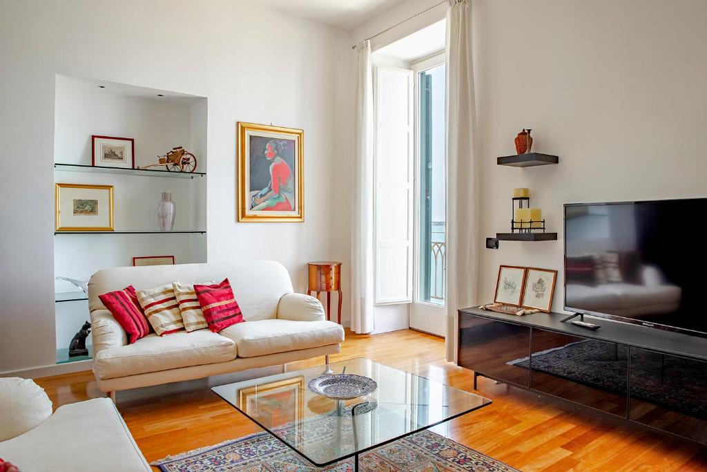 a living room with a white couch and a television at Seaview Design Homes in Ortigia by Wonderful Italy in Siracusa