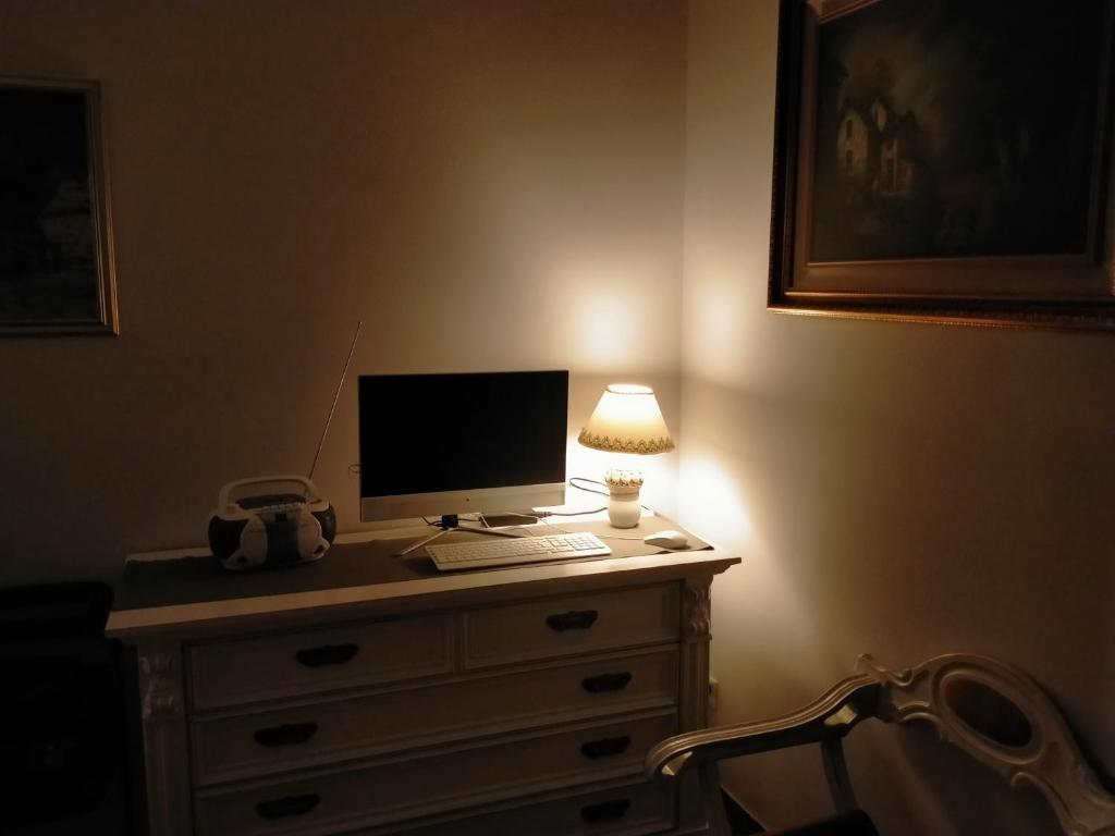 escritorio con ordenador en un tocador con lámpara en SERENDIPITY B&b, en Fabriano