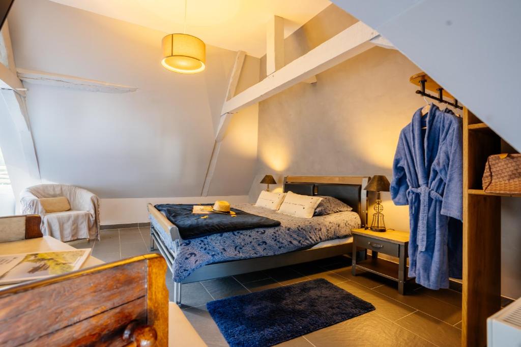 sypialnia z łóżkiem i krzesłem w pokoju w obiekcie La Forcerie maison d'hôtes et spa w mieście Châtelais
