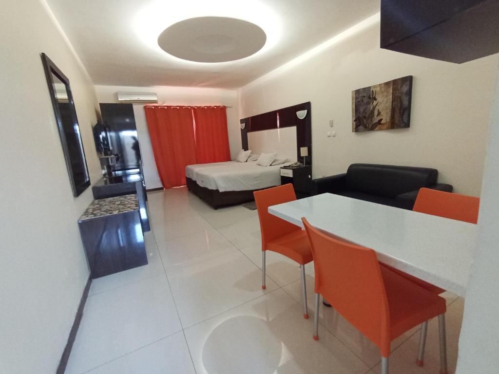 pokój hotelowy z łóżkiem, stołem i krzesłami w obiekcie Pensao Martins w mieście Maputo