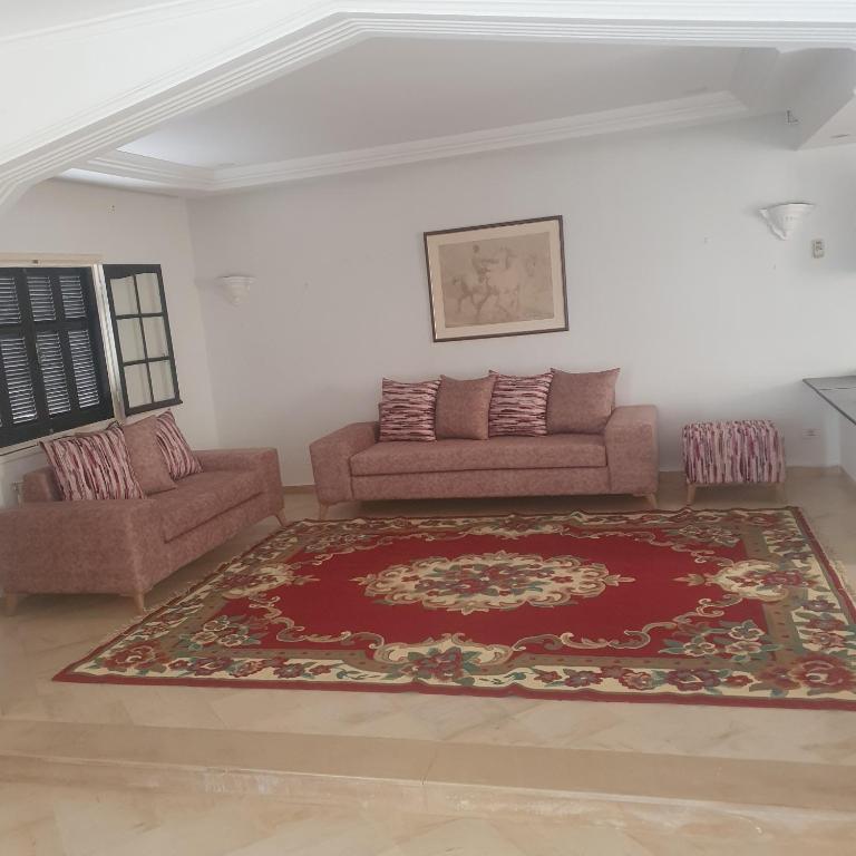 sala de estar con sofá y alfombra en Maison de vacances à la mer 5mn à pieds, en Borj el Khessous