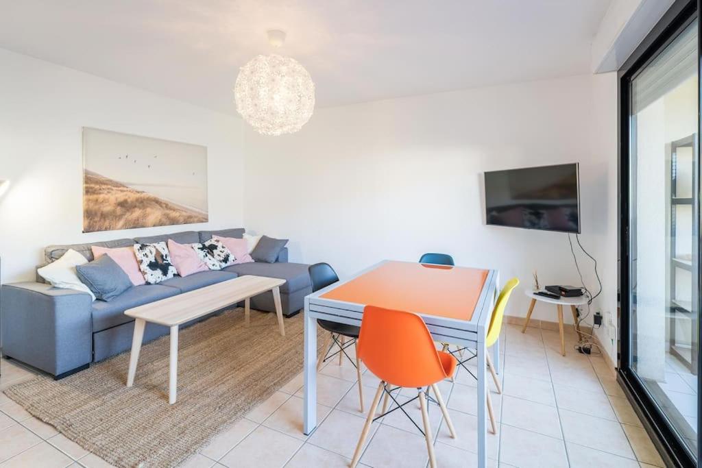 un salon avec un canapé bleu et une table dans l'établissement Le St Charles, Charmant T2, Terrasse, Centre ville, à Montpellier