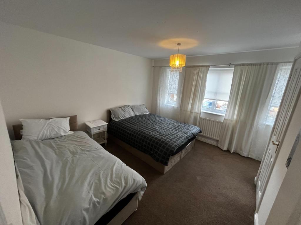 sypialnia z 2 łóżkami i oknem w obiekcie Modern 3 Bedroom House Close to Liverpool Centre w mieście West Derby
