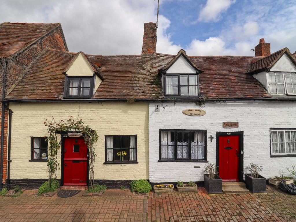 an old white house with red doors and windows at Avonmede in Tewkesbury