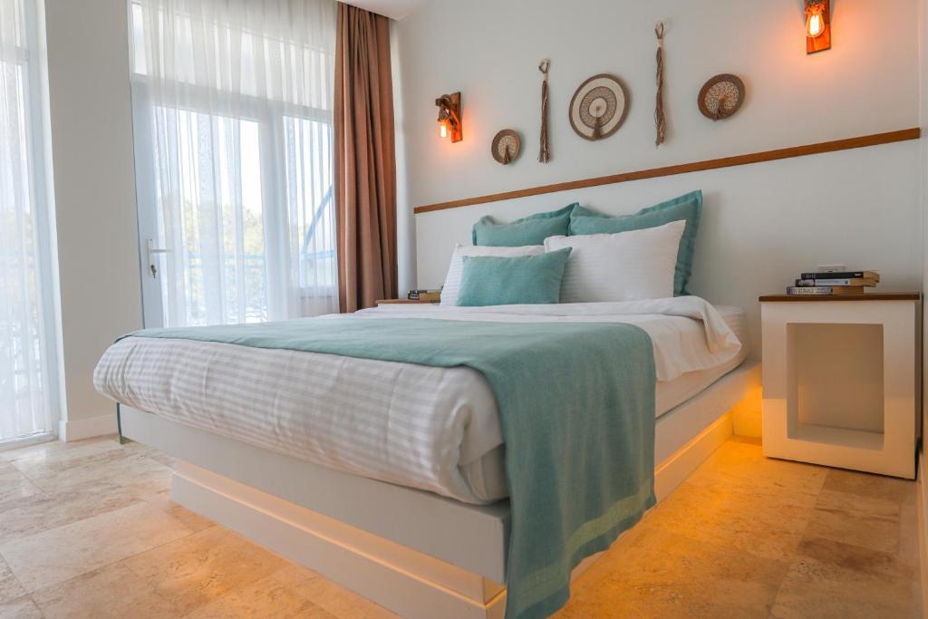 a bedroom with a large bed with blue and white at Mavi Cam Hotel Ayvalik in Sefaçamlık