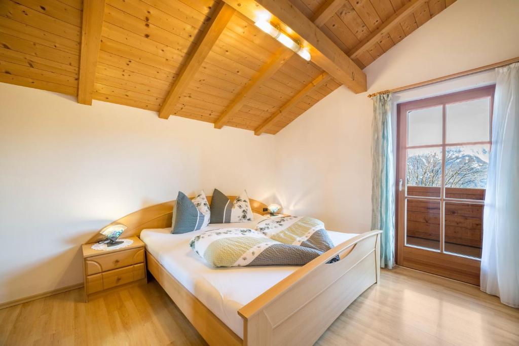 - une chambre avec un lit et une grande fenêtre dans l'établissement Schnatzhof Apartment Schwalbennest, à Naturno