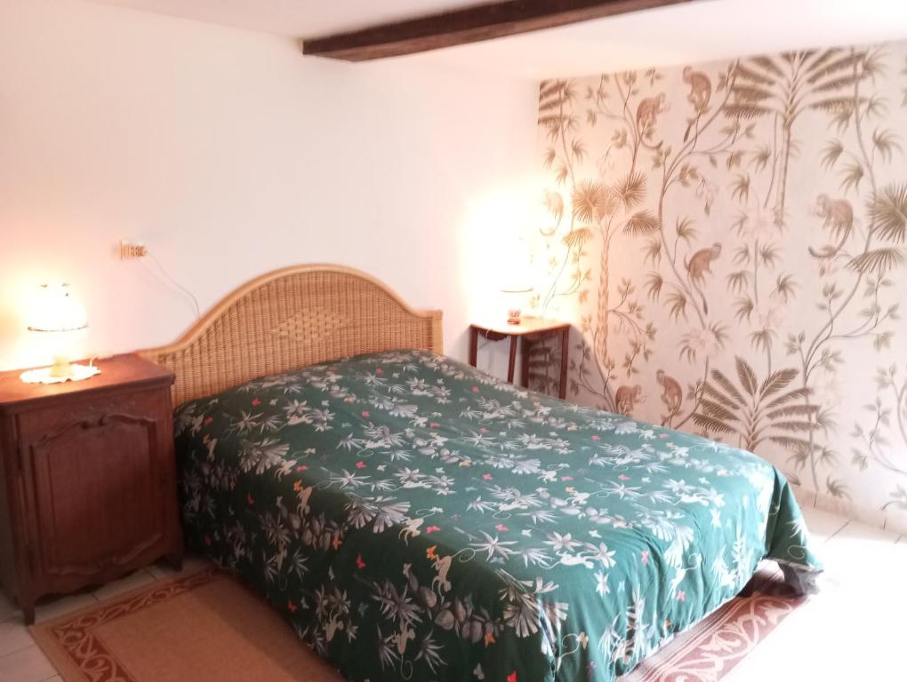 a bedroom with a bed with a green blanket at Entre forêts et prairies in Le Cercueil