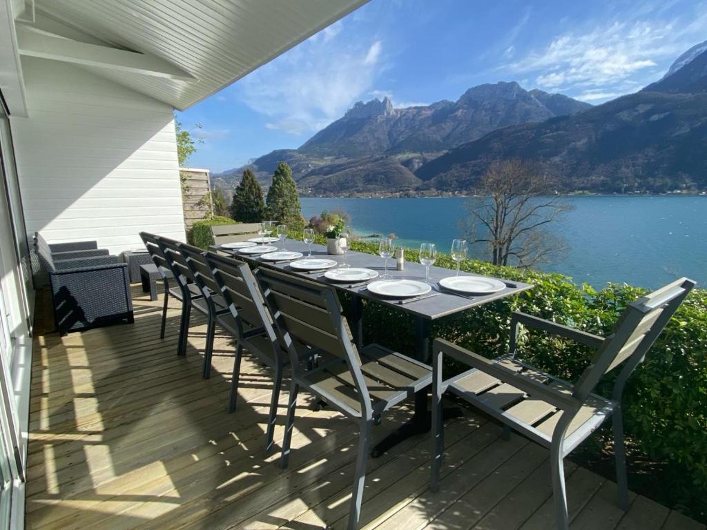 una mesa de comedor en una terraza con vistas al lago en Spacieuse Villa avec vue panoramique sur le lac, une Exclusivite LLA Selections by Location Lac Annecy, en Doussard
