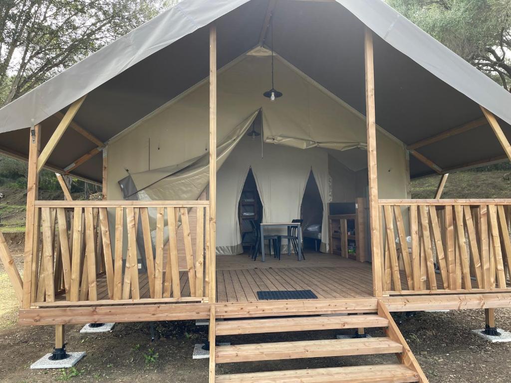 een tent met een houten terras en een tafel erin bij lodge lavallee in Belvédère