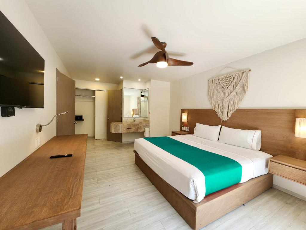 1 dormitorio con 1 cama grande y ventilador de techo en Siente Tulum en Tulum