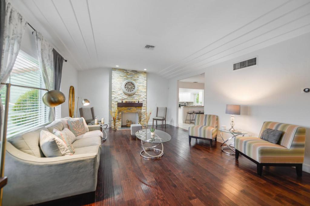 uma sala de estar com um sofá e cadeiras e uma lareira em Discover Serenity in this Tranquil Miami Home em Miami