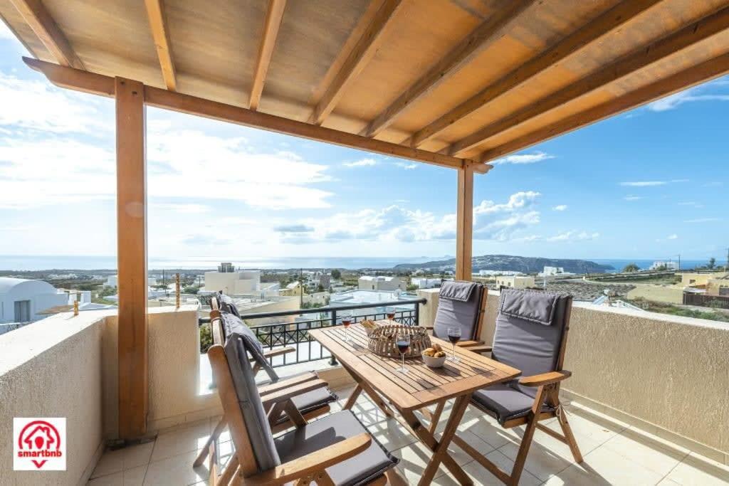 patio con mesa y sillas en el balcón en Villa naya, en Megalokori