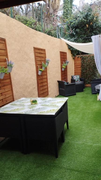 un patio avec une table et des chaises sur l'herbe dans l'établissement studio 1 étoile paisible,4 couchages,jardin privé, à Les Adrets-de-l'Estérel