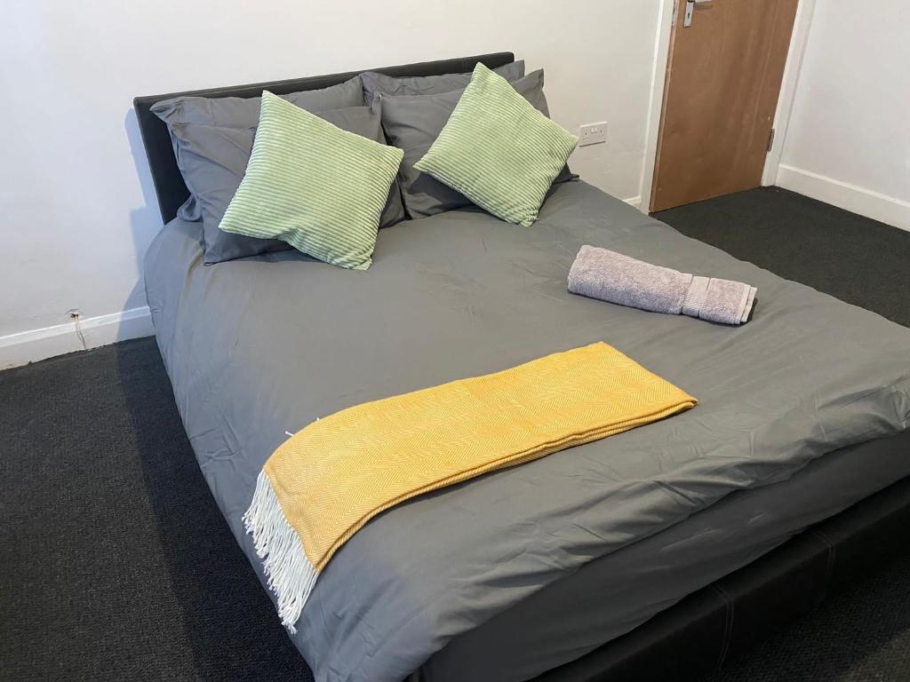 Una cama con dos almohadas y una toalla amarilla. en Beresford House en Longford