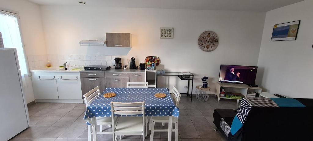 cocina con mesa y sillas en una habitación en Maison T2 avec terrasse 700m de l'océan aux BOUCHOLEURS- En été location vendredi à vendredi en Yves
