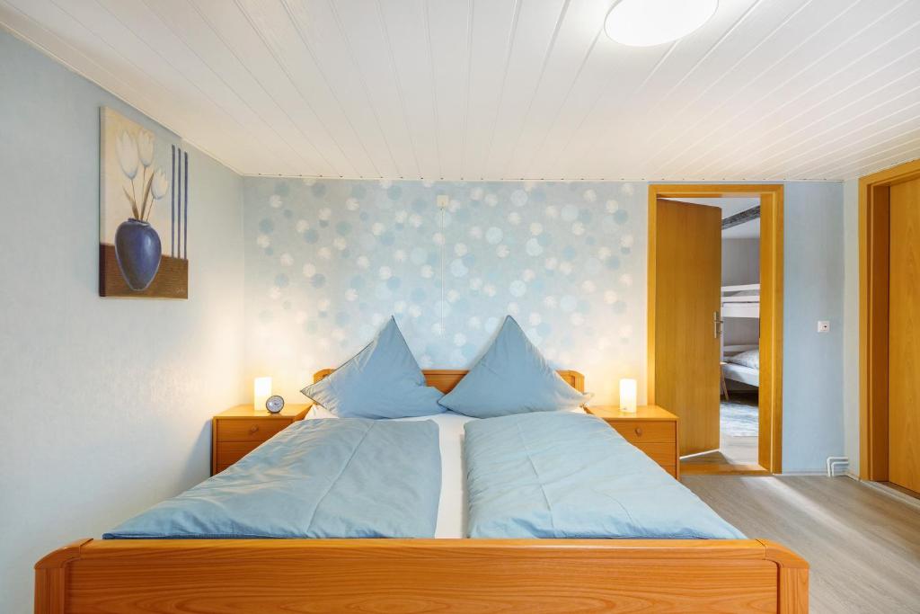 a bedroom with a bed with blue pillows at Urlaub an der Elbmündung in Neuenkirchen
