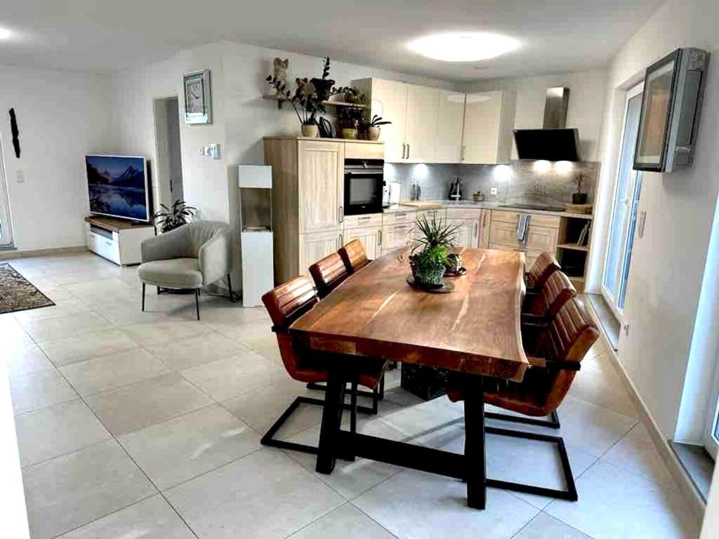 uma cozinha e sala de jantar com uma mesa de madeira e cadeiras em 2 bedrooms appartement with wifi at Tetange Kayl 