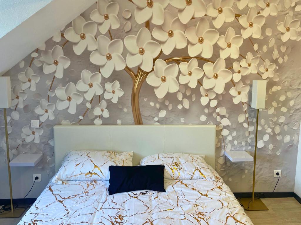 a bedroom with a bed with a flower wall at [Rêve doré] Studio Équipé, Wifi, Unique in Lourdes