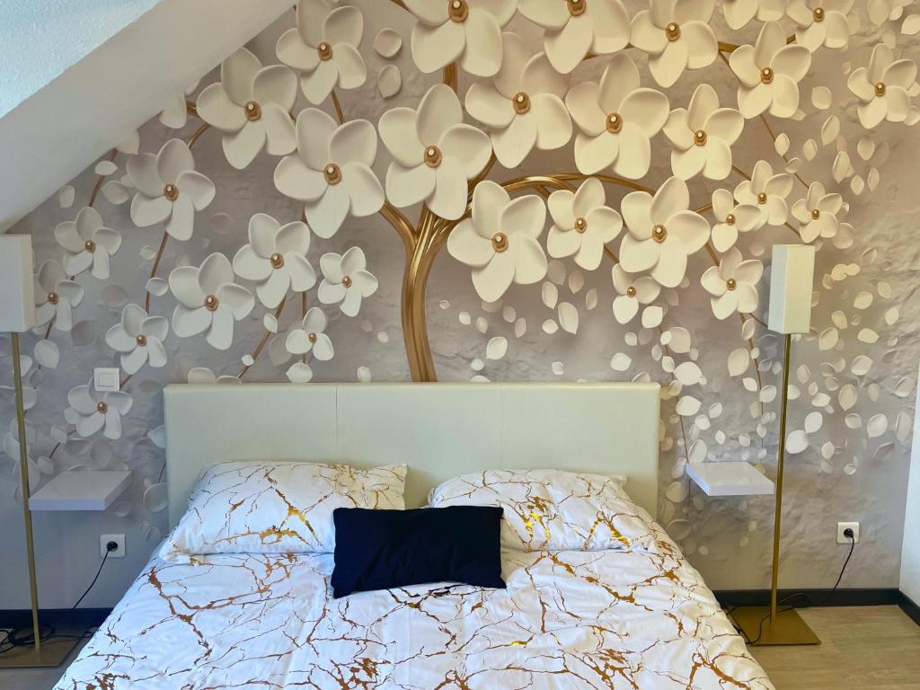 une chambre avec un lit avec un mur de fleurs dans l'établissement [Rêve doré] Studio Équipé, Wifi, Unique, à Lourdes