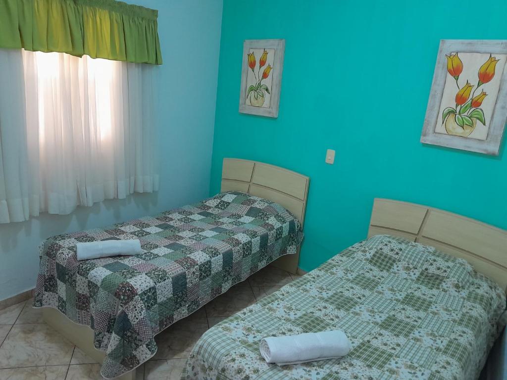 2 camas en una habitación con paredes azules en Cantinho do Paraíso en Águas de Lindóia