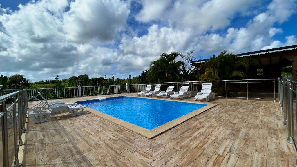 - une piscine sur une terrasse entourée de chaises dans l'établissement Les Villas Sarah, à Le Moule