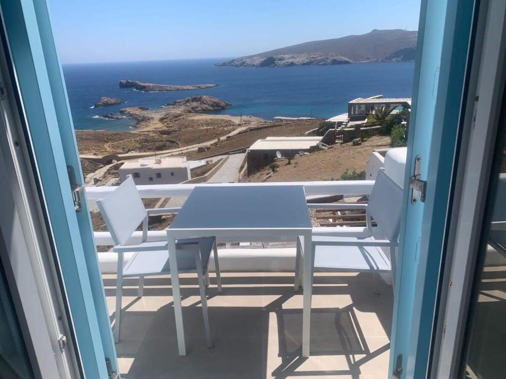 stół i krzesła na balkonie z widokiem na ocean w obiekcie Agean Studio with Breathtaking Views w mieście Agios Sostis Mykonos