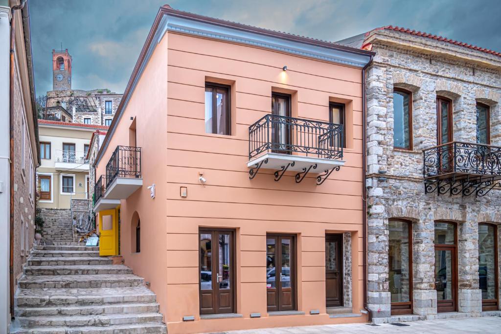 un edificio rosa con scale in città di Marquesa Boutique Hotel a Nafpaktos