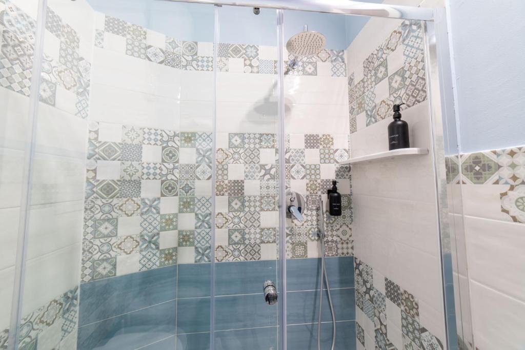 a bathroom with a shower with blue and white tiles at B&b Anna's home in Marina di Camerota
