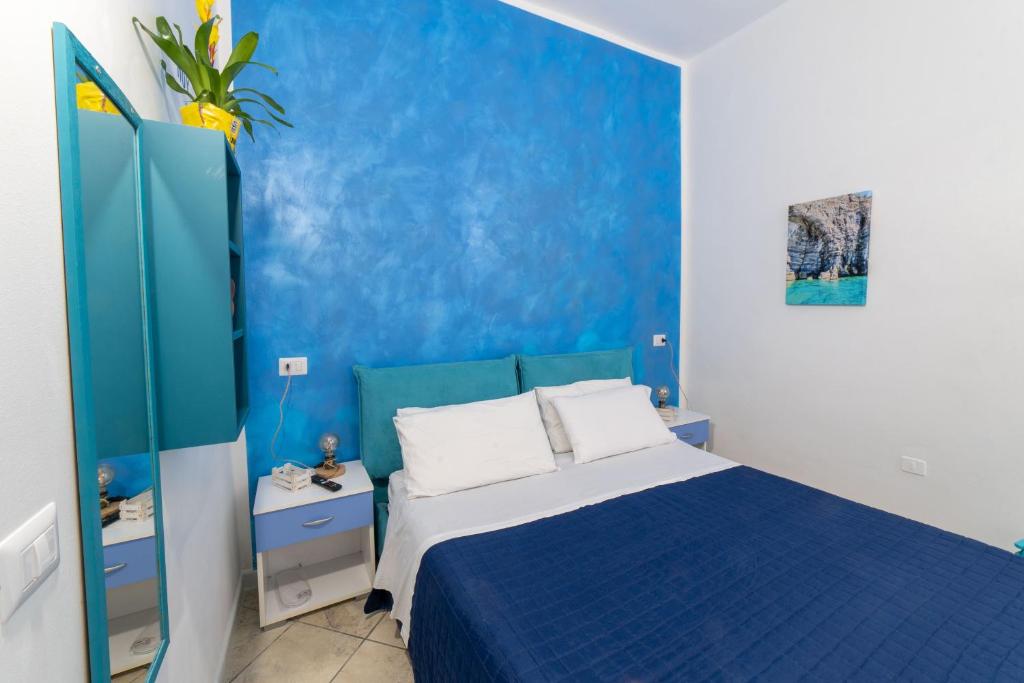 een blauwe slaapkamer met een bed en een blauwe muur bij B&b Anna's home in Marina di Camerota