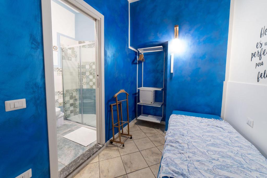a blue room with a bed and a shower at B&b Anna's home in Marina di Camerota