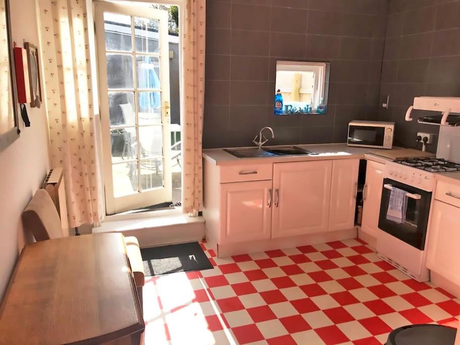 a kitchen with a red and white checkered floor at Aule Apartment in Bembridge