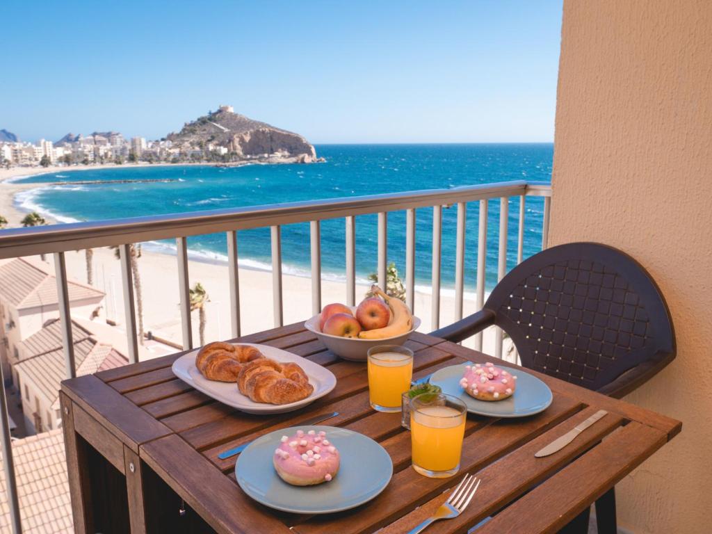 - une table avec des plaques de beignets sur un balcon donnant sur la plage dans l'établissement Frente al Mar con Garaje y Wifi - by Aloha Palma, à Águilas