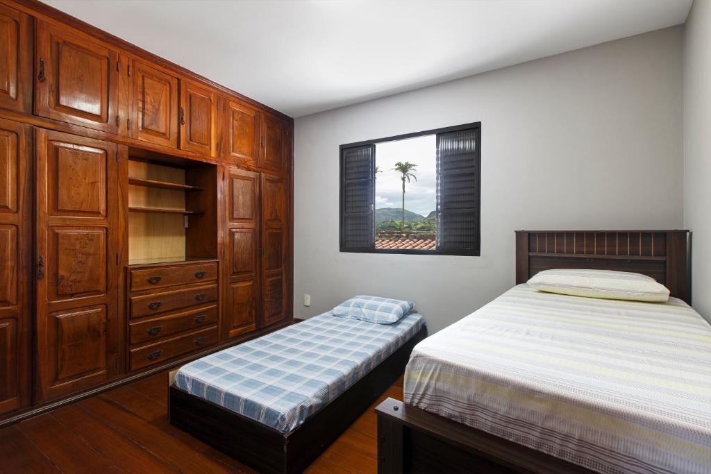a bedroom with two twin beds and a window at Aconchego São Francisco, Casa 100m Igreja São Francisco, Pet friendy in São João del Rei